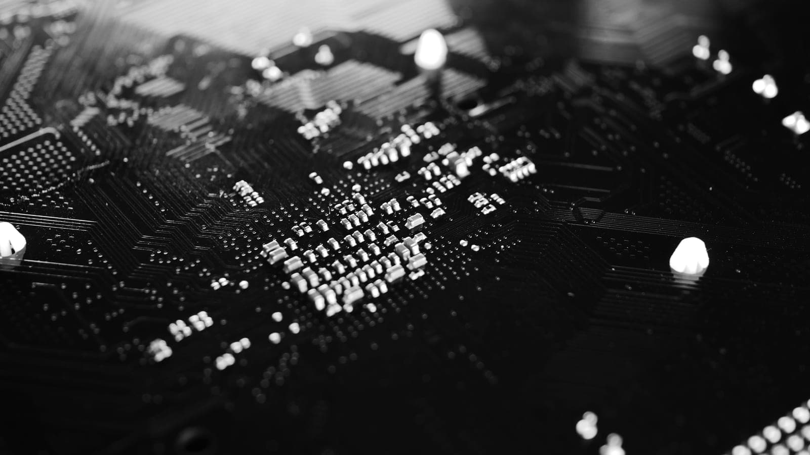 Black-and-white close-up of components and traces on a circuit board.