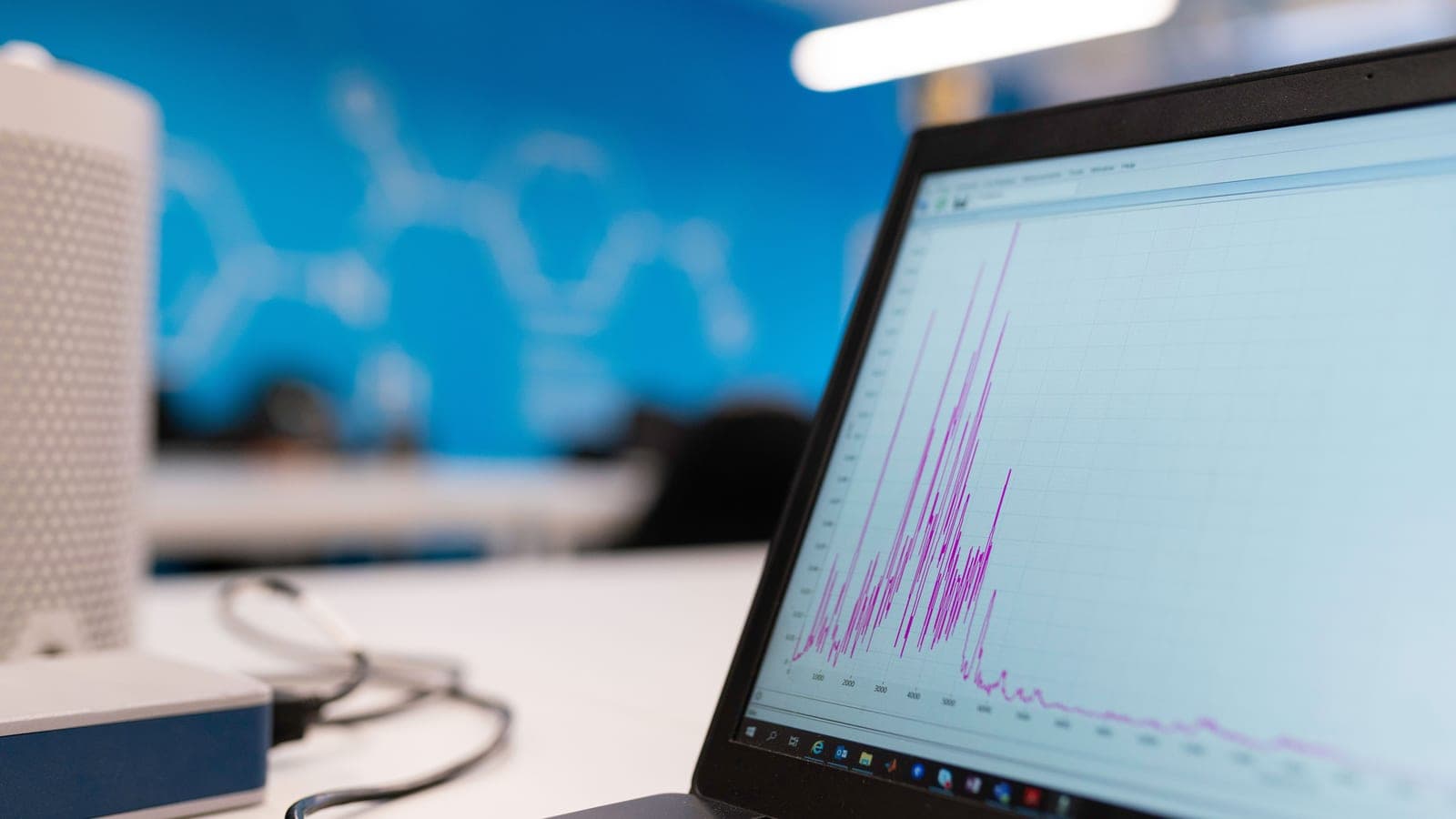 A laptop displays several coloured measurement curves in a workspace.